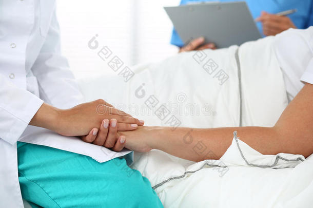 友好的女医生的手牵着病人的手