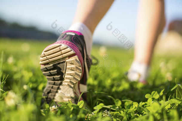 特写鞋底跑鞋在绿草地上。