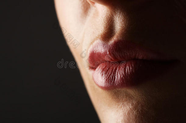 美丽完美的嘴唇。 美丽的年轻女人的嘴唇。 在黑色背景上特写