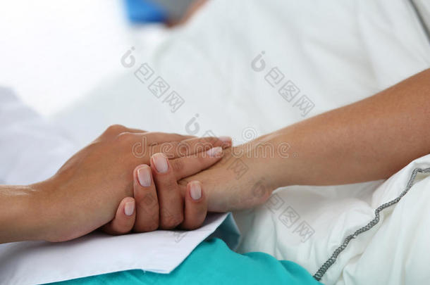 友好的女医生手牵着病人的手