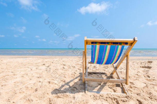 阳光明媚的一天，沙滩上五颜六色的椅子在寻找蓝色