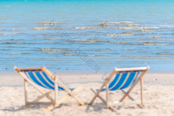 阳光明媚的一天，沙滩上的椅子散落在沙滩上寻找