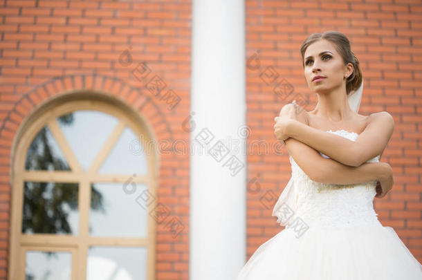 砖墙背景上的新娘。 结婚礼服