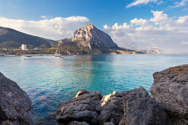 美丽的夏天日落在大海与山和石头