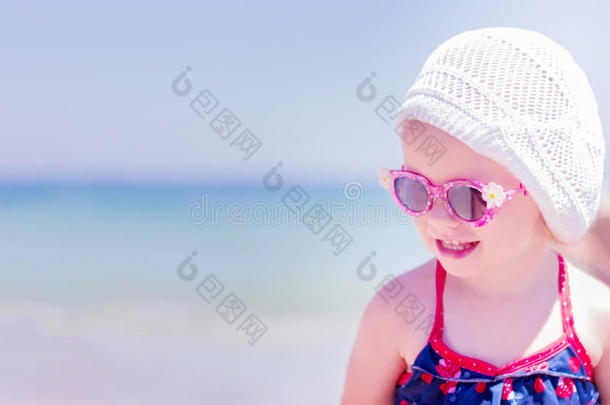 美丽的小女孩在大海的背景上笑。