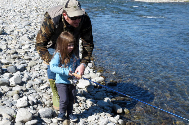 欢快的父亲和女儿一起在<strong>河边钓鱼</strong>