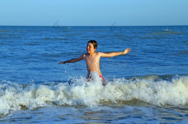 孩子在海中嬉戏跳跃着波涛<strong>汹涌</strong>的<strong>海浪</strong>