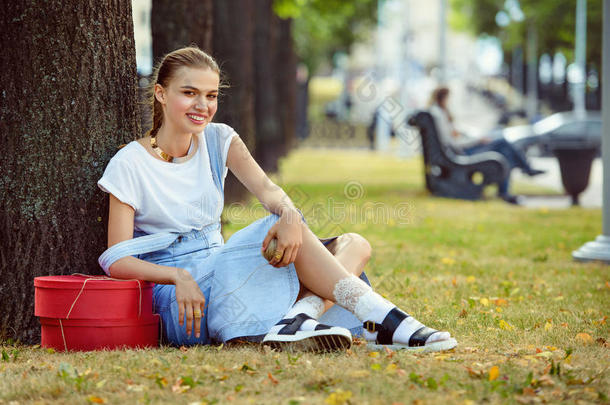 女孩躺在草地上，穿着时髦的衣服，丝袜，一件连衣裙