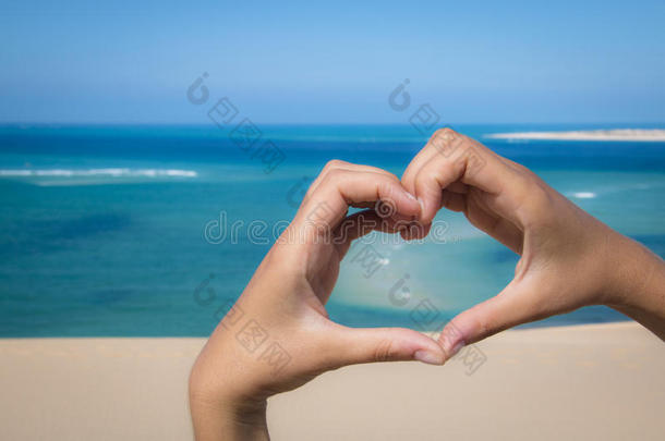 双手在海滩上做一个心脏标志