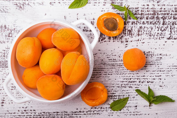 白色桌子上碗里的新鲜杏子。