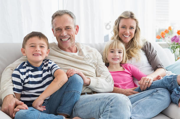 坐在沙发上微笑的一家人的画像