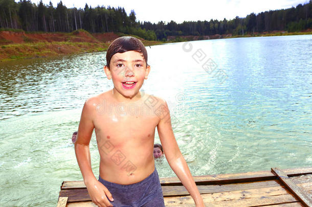 在他们的暑假里在湖里游泳的男孩
