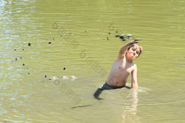 男孩在水里扔<strong>泥巴</strong>