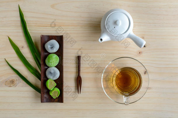 大福绿茶和芝麻馅与一杯茶在木塔上
