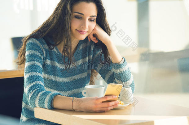 自信的年轻女人在咖啡馆使用智能<strong>手机</strong>