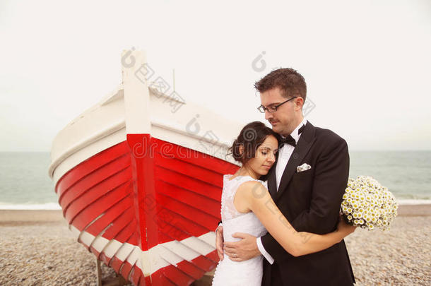 新郎和新娘在岸边靠近一艘<strong>红船</strong>