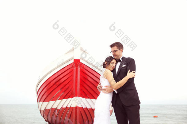 新郎和新娘在岸边靠近一艘红船