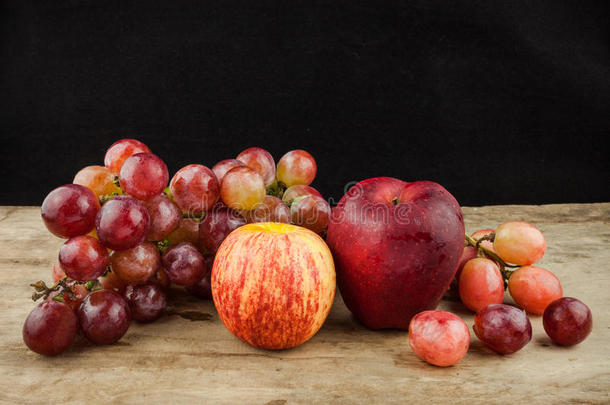 新鲜水果，红色葡萄和红色苹果在木材背景