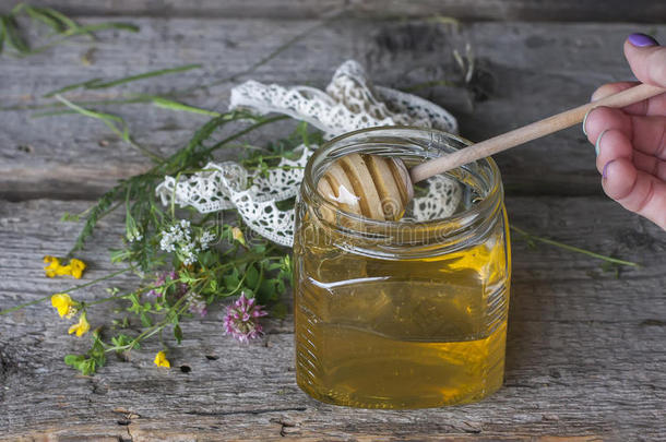 新鲜的<strong>天然蜂蜜</strong>在一个罐子里，<strong>蜂蜜</strong>勺子在老式的木制上