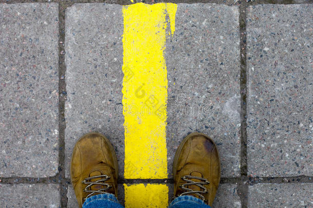 脚踩在人行道上的黄色鞋子里