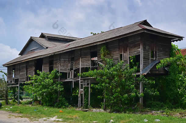 东南亚一座废弃的传统风格的私人木制建筑，杂草丛生