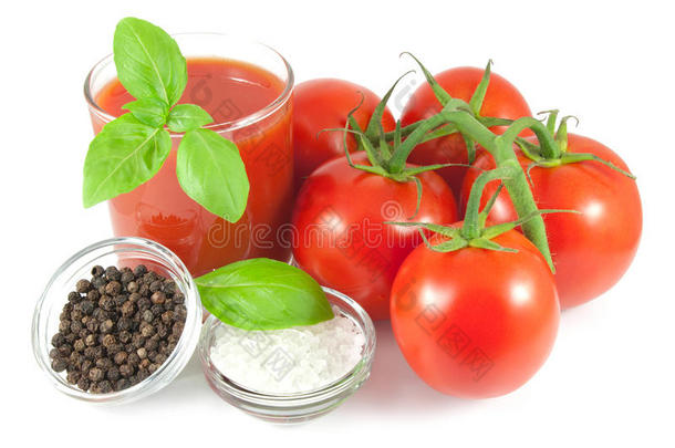 一束带罗勒叶的新鲜西红柿，一杯西红柿汁和一碗黑胡椒和海盐