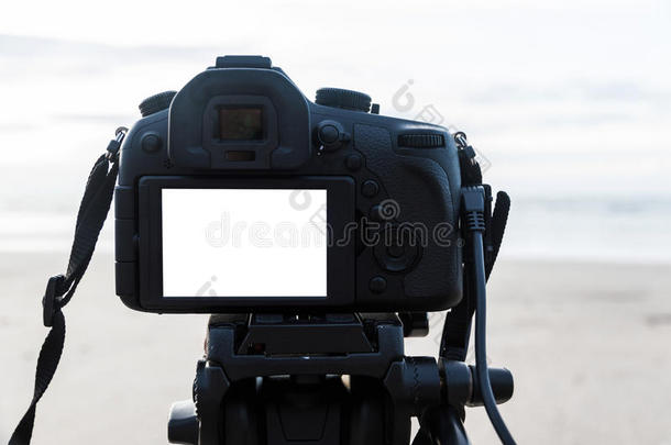 <strong>数码</strong>相机在三脚架上的白色<strong>屏</strong>幕在海滩上