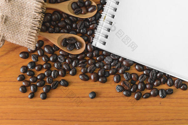 木勺咖啡豆和木桌上的便签簿。