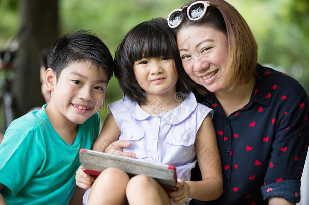 亚洲家庭正在一起玩电脑平板电脑