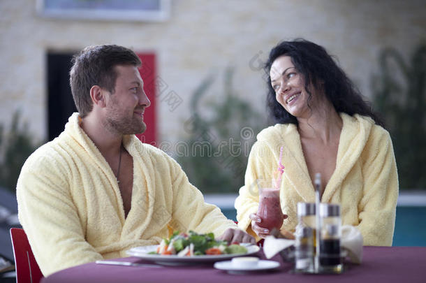 一对穿着浴袍的可爱夫妇在酒店一起吃早餐