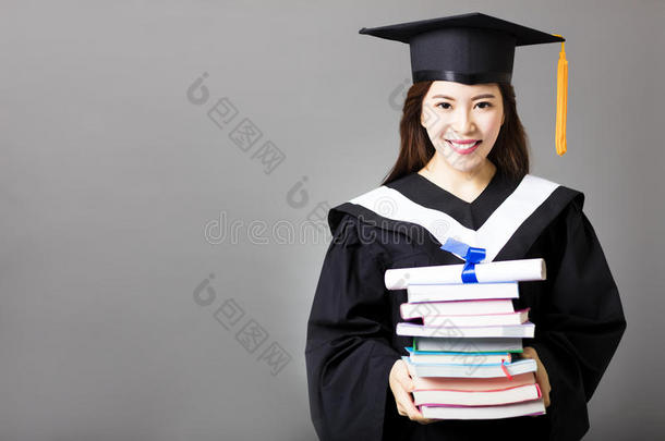 美丽的年轻毕业生持有文凭和书籍