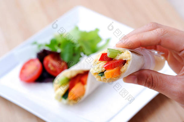 手拿一个健康的零食包装与胡萝卜，辣椒和一个SI