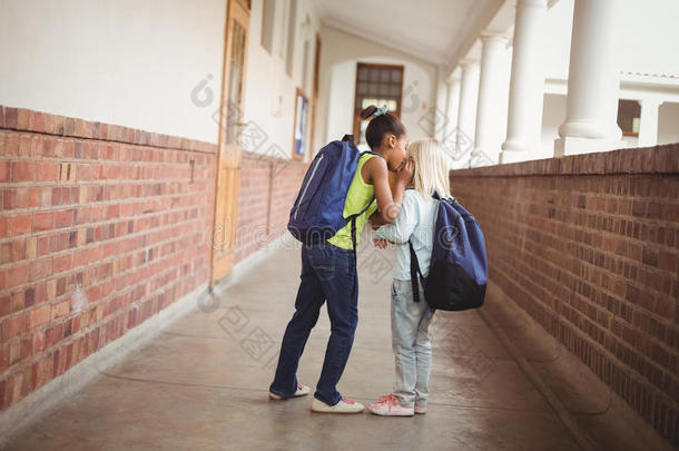 可爱的小学生在走廊里窃窃私语