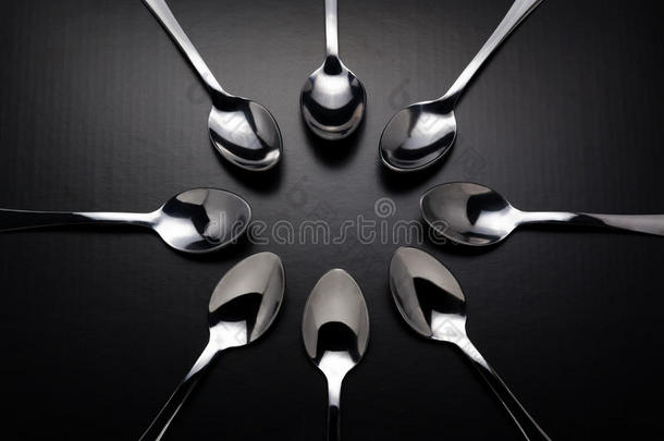 黑色背景上有八个<strong>不锈钢勺</strong>子。