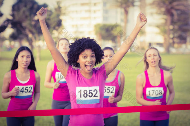 为赢得乳腺癌马拉松而欢呼的年轻女子