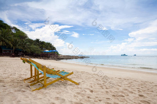 白色沙滩上的沙滩椅，天空乌云密布