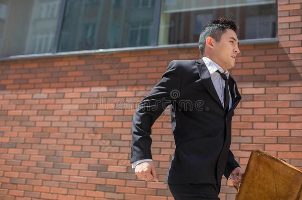 中国年轻商人在城市街道上跑步