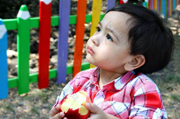 小男孩在儿童游乐场吃苹果