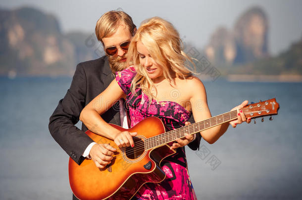 海滩上吉他手吉他的金发女孩