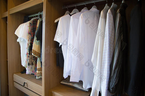 衣服挂在设计师服装店的架子上，现代衣柜里挂着一排布，老式房间里