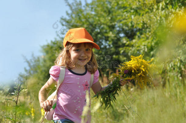 一个微笑的小女孩，带着一束田野的夏花，沿着森林的小径奔跑