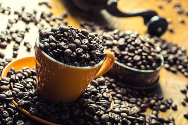 咖啡。 咖啡杯装满咖啡豆，咖啡磨床在背景