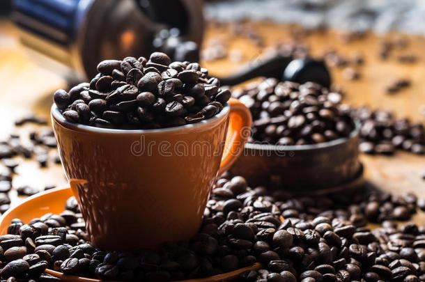 咖啡。 咖啡杯装满咖啡豆，咖啡磨床在背景