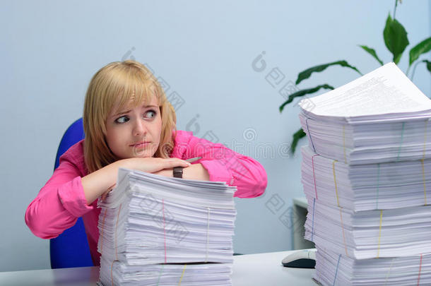 办公室里的女孩绝望地看着那堆文件