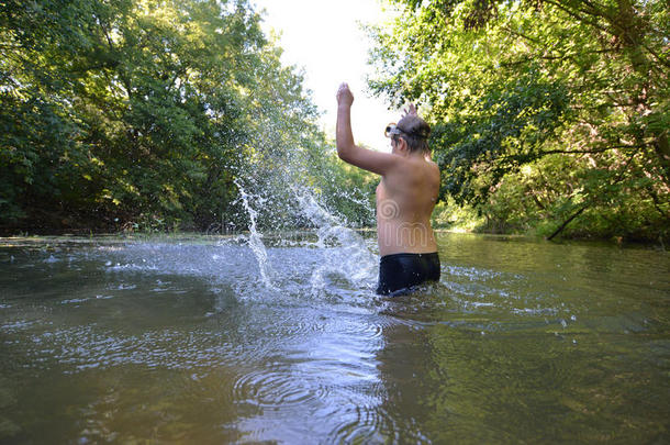 男孩少年夏天在河里游泳