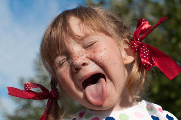一幅小女孩的肖像，展示了皮皮的长袜，并展示了她的舌头