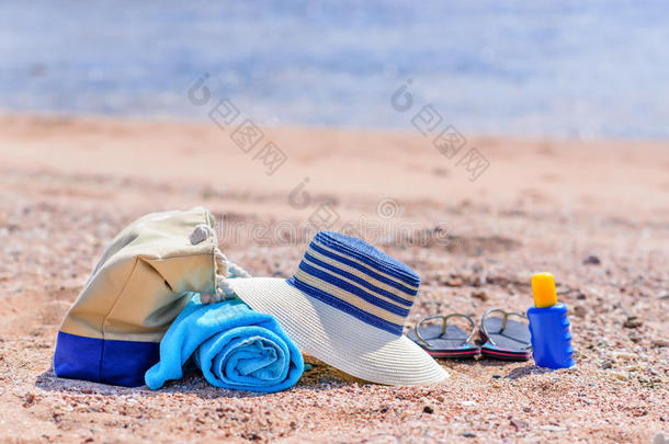 阳光明媚的沙滩上的沙滩袋和太阳帽