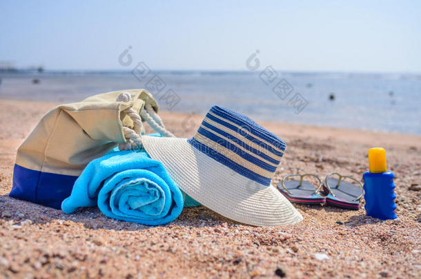 阳光明媚的沙滩上的沙滩袋和太阳帽