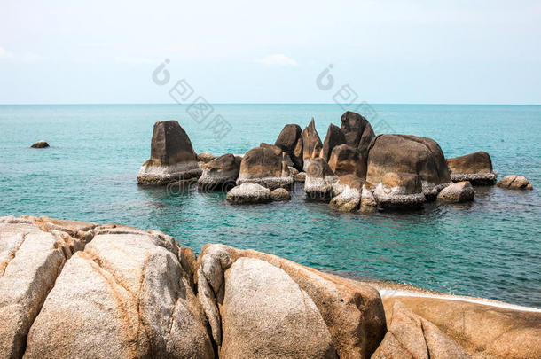 海岸上充满了岩石，<strong>田园</strong>诗般的蓝海和晴朗的天空。 t