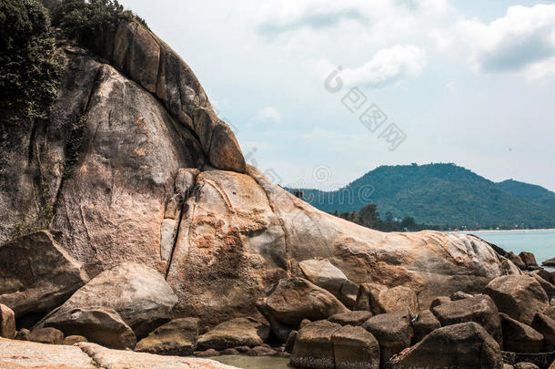 海岸上充满了岩石，田园诗般的蓝海和晴朗的天空。